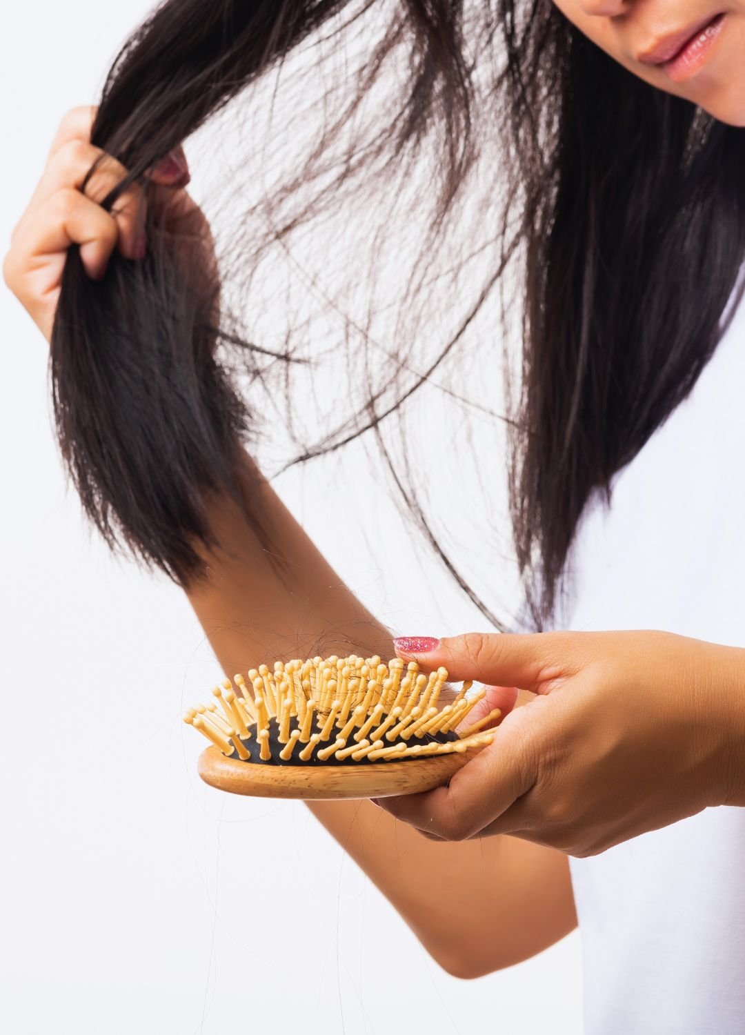 Femme se tenant les cheveux après avoir brossé ses cheveux et ayant sa brosse dans une main