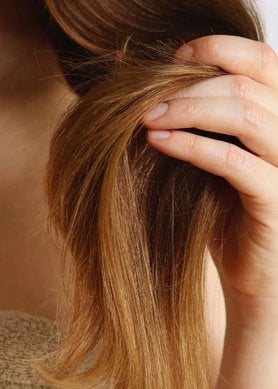 Femme ayant ses cheveux dans les mains