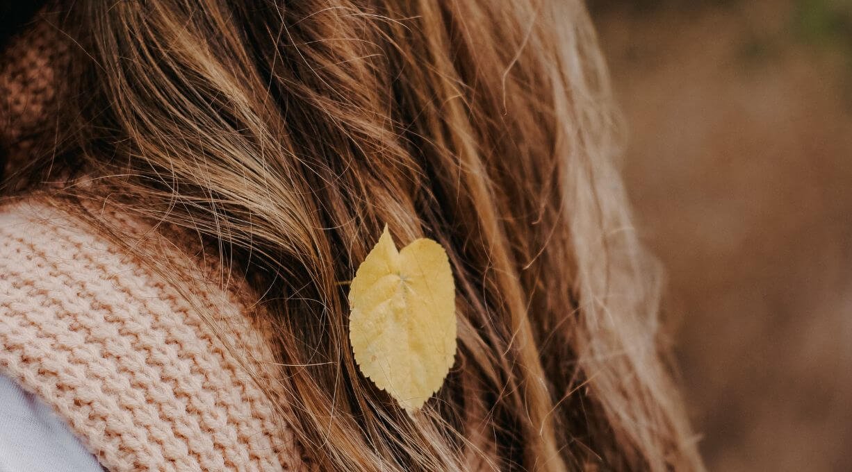 Femme ayant une feuille morte dans ses cheveux