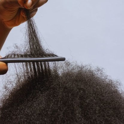personne qui peigne des cheveux crêpus