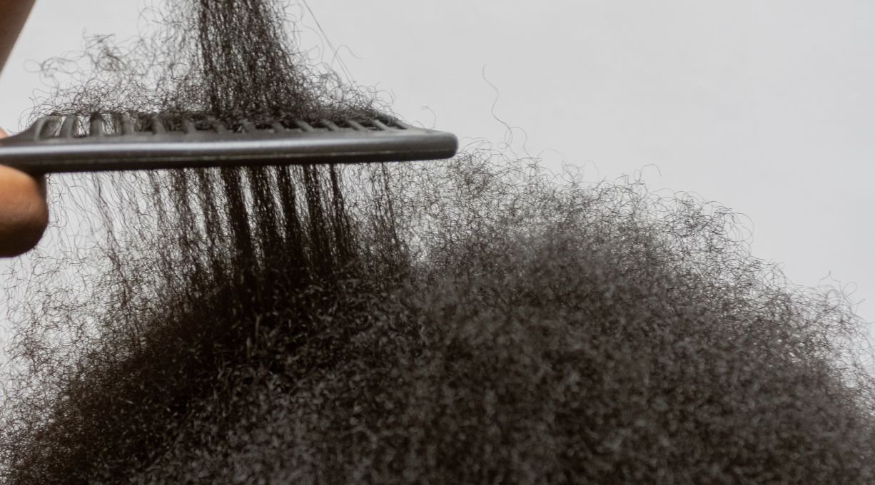 personne qui peigne des cheveux crêpus