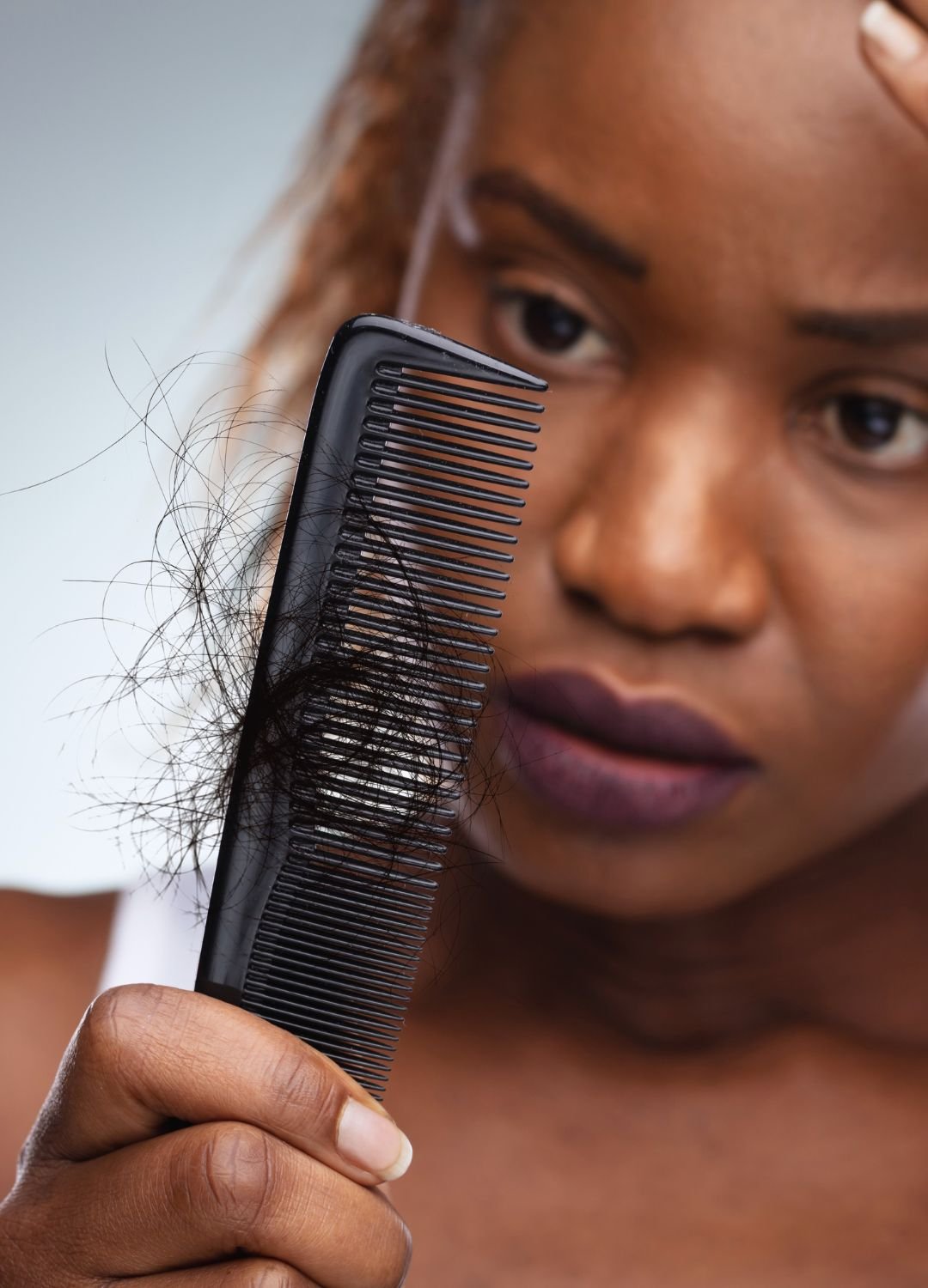 femme regardant son peigne ayant des cheveux dessus