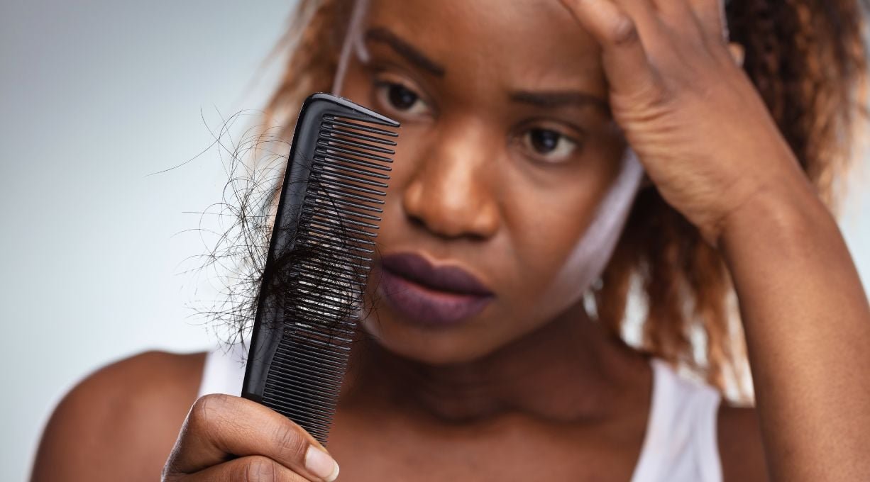 femme regardant son peigne ayant des cheveux dessus