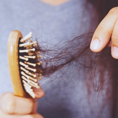 Femme ayant une brosse à cheveux avec plein de cheveux morts