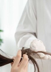Femme assise dans un fauteuil chez un professionnel de la santé capillaire pour un diagnostic cheveux