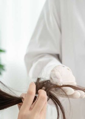 Femme assise dans un fauteuil chez un professionnel de la santé capillaire pour un diagnostic cheveux