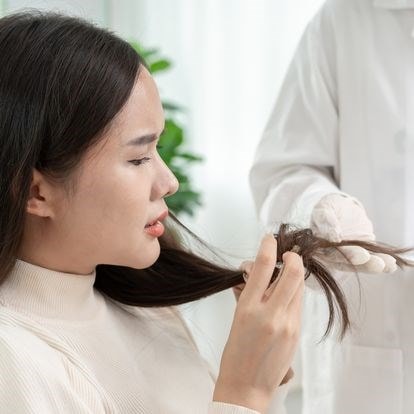 Femme assise dans un fauteuil chez un professionnel de la santé capillaire pour un diagnostic cheveux