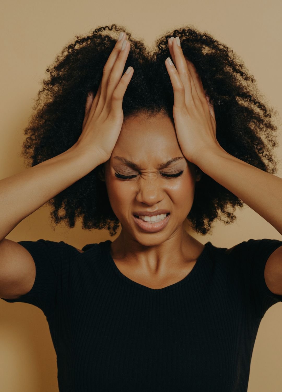 Femme aux cheveux afro se tirant les cheveux et faisant une grimace