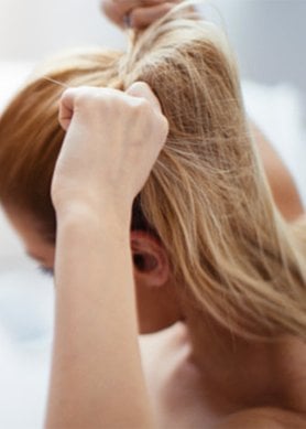 femme se faisant une queue de cheval