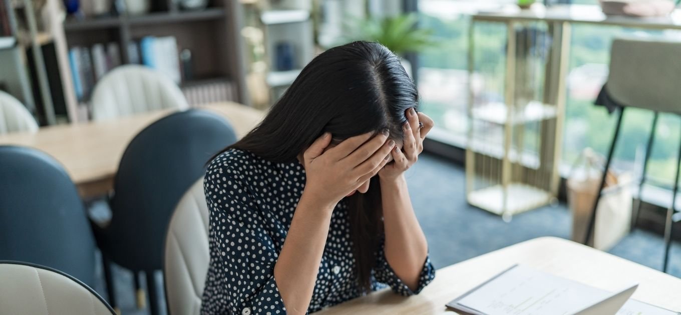 Femme se prenant la tête dans ses mains