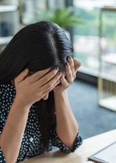 Femme se prenant la tête dans ses mains