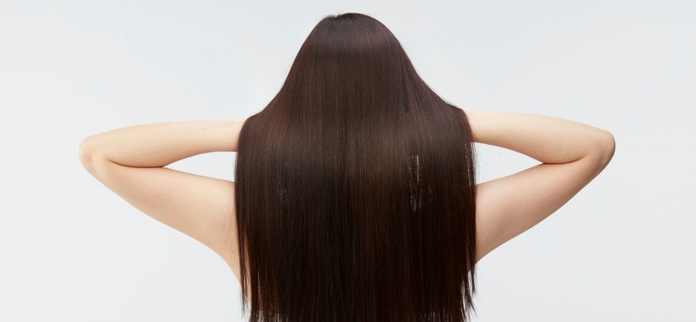 Femme aux longs cheveux ayant ses mains dans ses cheveux