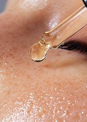 Application d'un sérum sur le visage d'une femme
