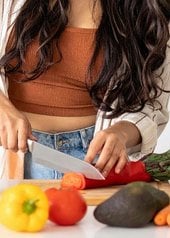 Femme coupant des légumes dans une cuisine