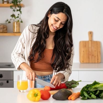 Femme coupant des légumes dans une cuisine