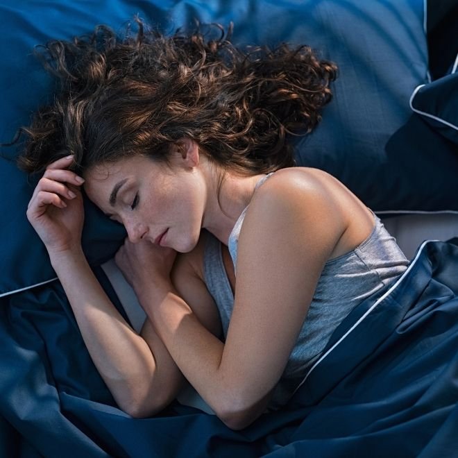 Femme qui dort dans son lit